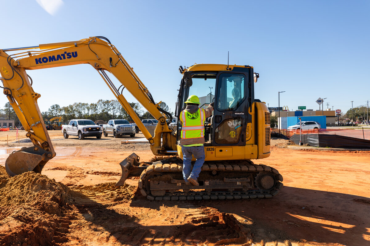 Site & Utility operator boarding a Komatsu excavator on site