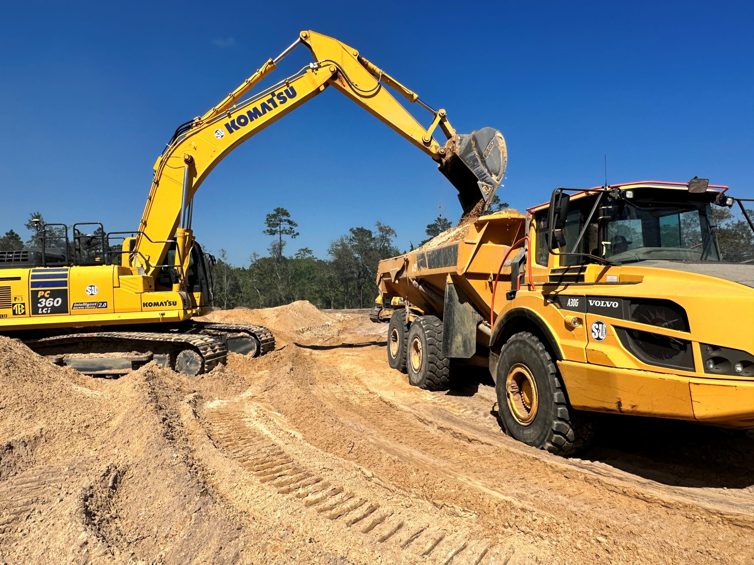 Site & Utility crews installing underground utilities in a deep shored trench